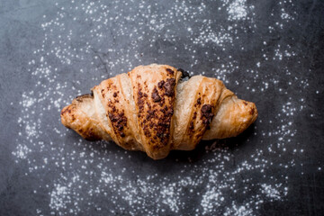 Delicious freshly baked croissants with chocolate on a dark background. French breakfast. Delicious pastries close-up. The context of a bakery with delicious bread. Confectionery products.