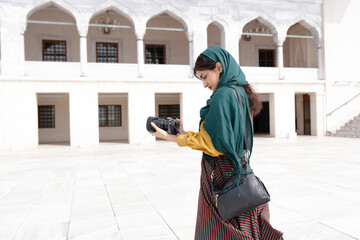 Young middle eastern woman using DSLR camera