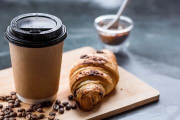 Delicious freshly baked croissants with chocolate and coffee on a dark background. French breakfast. Delicious pastries close-up. The context of a bakery with delicious bread. Confectionery products.