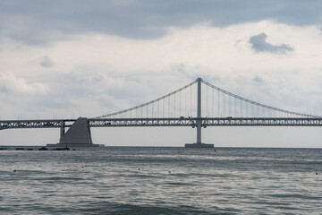 Gwangalli Beach and Gwangan Bridge in Busan during winter morning cloudy day at Suyeong-gu , Busan  South Korea : 9 February 2023