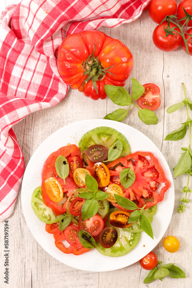 Wall mural Healthy tomatoes salad with sauce and basil