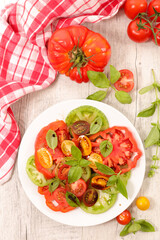 Healthy tomatoes salad with sauce and basil