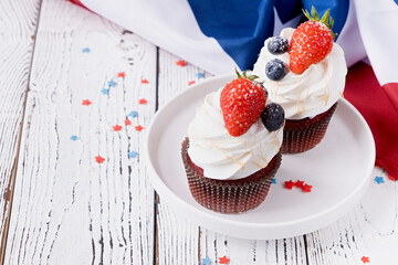 Sweet cupcakes with blueberries and strawberry , flag background