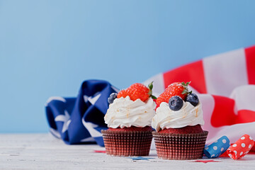 Sweet cupcakes with blueberries and strawberry , usa flag on blue background