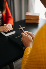 Two people reading and study bible in home and pray together.Studying the Word Of God With Friends..