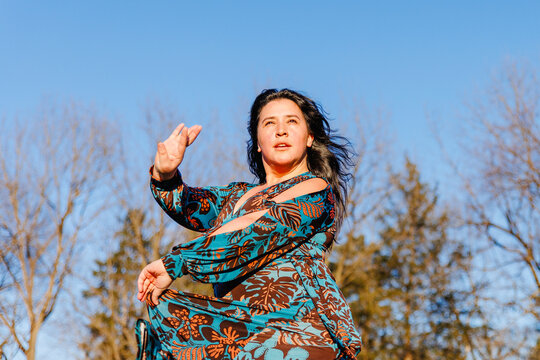 A beautiful intense woman dances flamenco outside