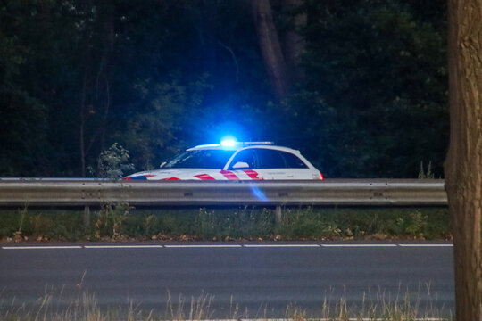 Police car on highway with flashing blue light after accident