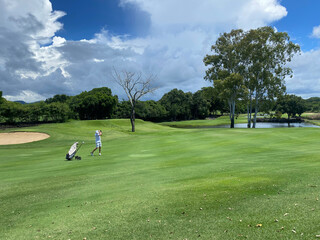 Golfer strikes with club on golf course