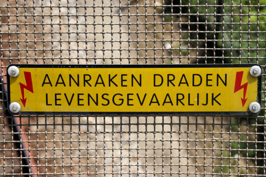 Sign at a viaduct in dutch "aanraken dragen levensgevaarlijk" which means touching wires is dangerous