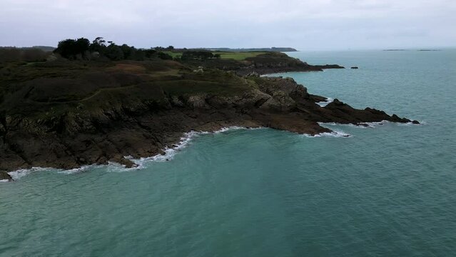 Rocky and jagged cliff with old building of Daules guardhouse between Plage du Verger, Cancale in France. Aerial sideways