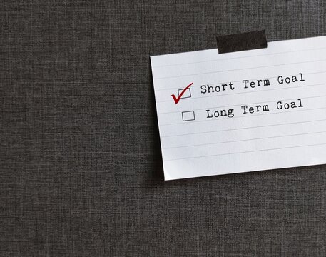 Note stick on wallpaper with checkbox SHORT TERM GOAL and LONG TERM GOAL, concept of goals setting goals, easy one to achieve soon and the bigger ones to accomplish in the future.