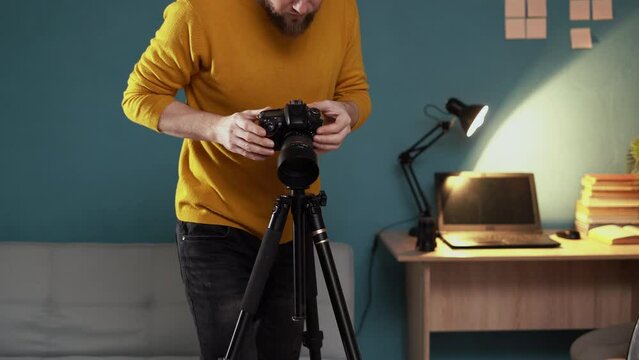 Freelance photographer man at home office shooting product set-up camera on tripod