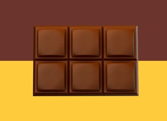 3D rendering of milk chocolate on brown and yellow background
