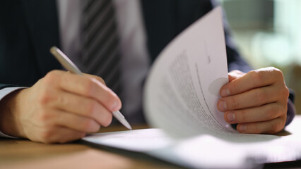 Businessman in suit signing document at work in office closeup. Earning strategies in business...