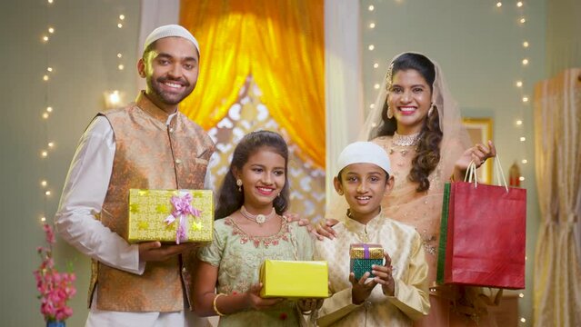 happy young indian muslim family celebrating and enjoying ramdan festival by shopping online during offer sales - concept of gifting, reletionship and bonding.