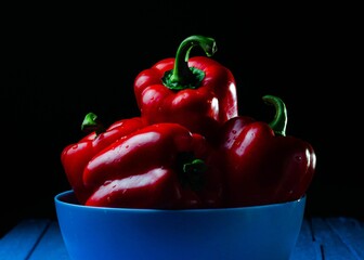 Blue bowl filled with red peppers on top of a table