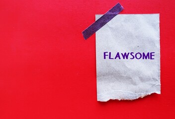 Craft paper stick on red copy space background with handwritten text FLAWSOME, refers to individual who embraces their flaws and loving themselves, knowing they are awesome, with all those flaws