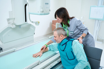 Doctor standing and helping patient to making x-ray at radiology room
