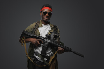 Naklejka premium Shot of cheerful pirate of african ethnic with rifle in setting of post apocalypse.
