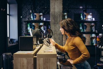Portrait of happy smiling woman shopping a new smart watch in tech store. Technology people concept