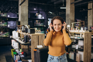 Happy customer choosing headphones in audio store
