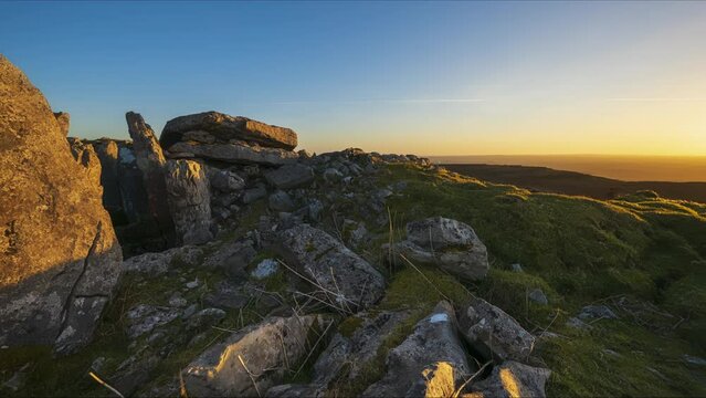 Panorama motion timelapse of rural nature landscape with ruins of prehistoric passage tomb stone ruin in the foreground during sunset viewed from Carrowkeel in county Sligo in Ireland.