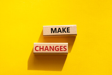 Make changes symbol. Wooden blocks with words Make changes. Beautiful yellow background. Business and Make changes concept. Copy space.