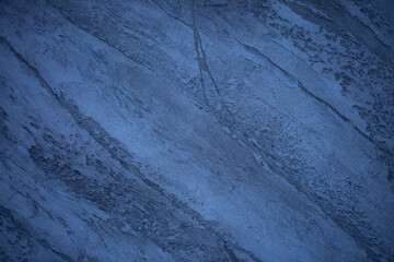 Fototapeta premium Blue background of decorative plaster with abstract spots. Unusual texture of this wall with beautiful patterns, creative surface background. Finishing coating for building cladding.