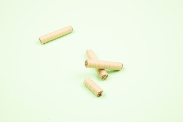 wafer rolls with chocolate isolated on light green background