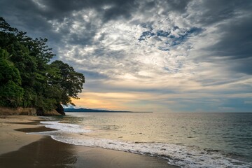 Seashore scenery with beautiful, splashing waves and sunset skies