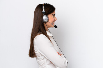Telemarketer caucasian woman working with a headset isolated on white background in lateral position