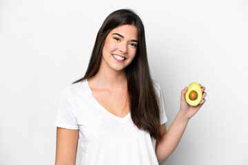 Young Brazilian woman holding an avocado isolated on white background smiling a lot