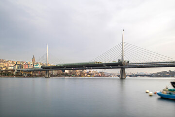 Fototapeta na wymiar Long exposure. View of Haliç Metro Bridge connecting Azapkapı (Beyoğlu) and Unkapanı (Fatih) (Halic Metro Bridge). blue sky Istanbul Turkey