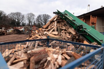 Obraz premium the dumpster is filled with chopped wood outside of a building