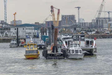 Foto op Plexiglas Stad aan het water Boats floating on the water at a dock near a city