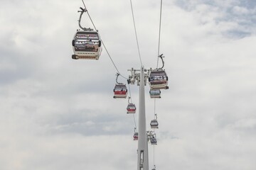 View of gondola lifts dangling from the side of a cable in a mountainous area