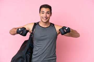 Young sport caucasian man with sport bag isolated on pink background proud and self-satisfied