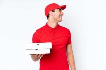 Pizza delivery caucasian man with work uniform picking up pizza boxes isolated on white background laughing in lateral position