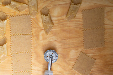 A top-down view unveils the artistry of pasta preparation, with a pasta cutter roller poised to...