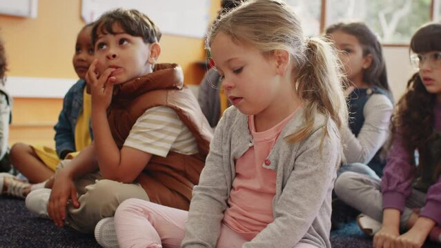Multiethnic elementary school children actively engaging in a lesson led by their teacher in a classroom