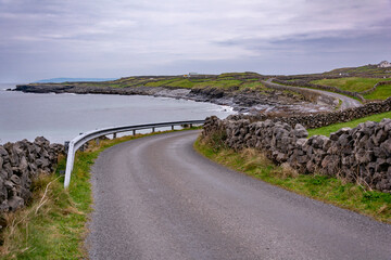 Irish country road with stone walls by the shore