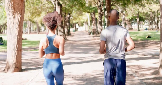 Fitness, running and couple in park from back for exercise and bonding in nature together. Marathon training, black man and woman run on garden path for health, wellness and workout with green trees.
