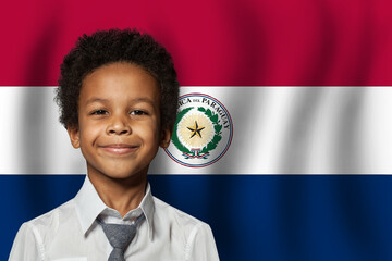 Paraguayan kid boy on flag of Paraguay background. Education and childhood concept