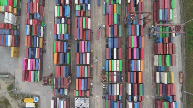 Aerial view of bustling container terminal at Colombia's busiest port is a sight to behold. The scale of the operation and constant activity of cranes moving goods onto cargo ships is impressive. 