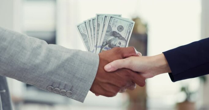 Handshake, bribery and crime with business people in an office exchanging the payment of cash for extortion. Money, crime and blackmail with two employees shaking hands in a deal for corruption