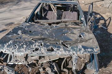 A civilian car is damaged by fragments of artillery shells (concept: killing civilians)