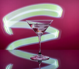 Martini cocktail in a glass against the background of neon lights