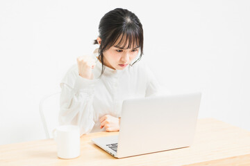 PCを使いながら怒っている若い女性