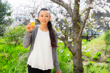 お花見でビールを飲む女性 