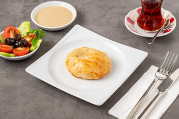 Izmir boyoz on a white porcelain plate on a stone table